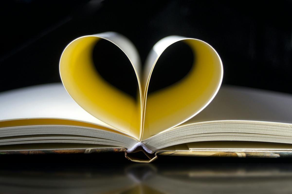 An open book with pages bent into the shape of a heart
