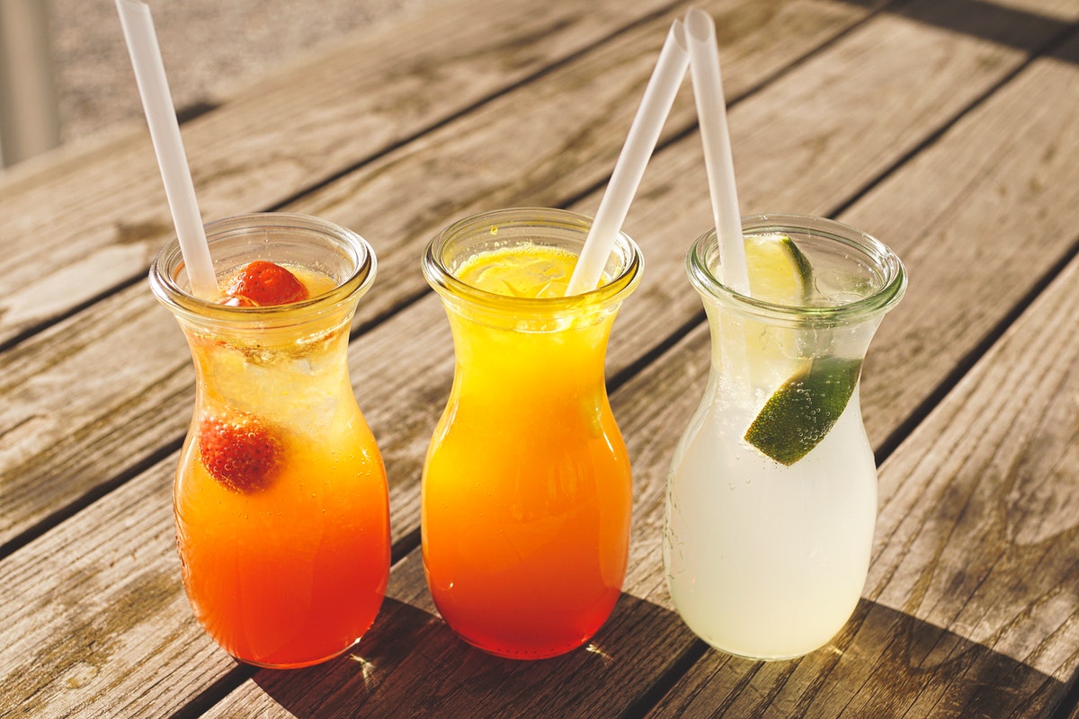 Three summery drinks on a wooden deck..