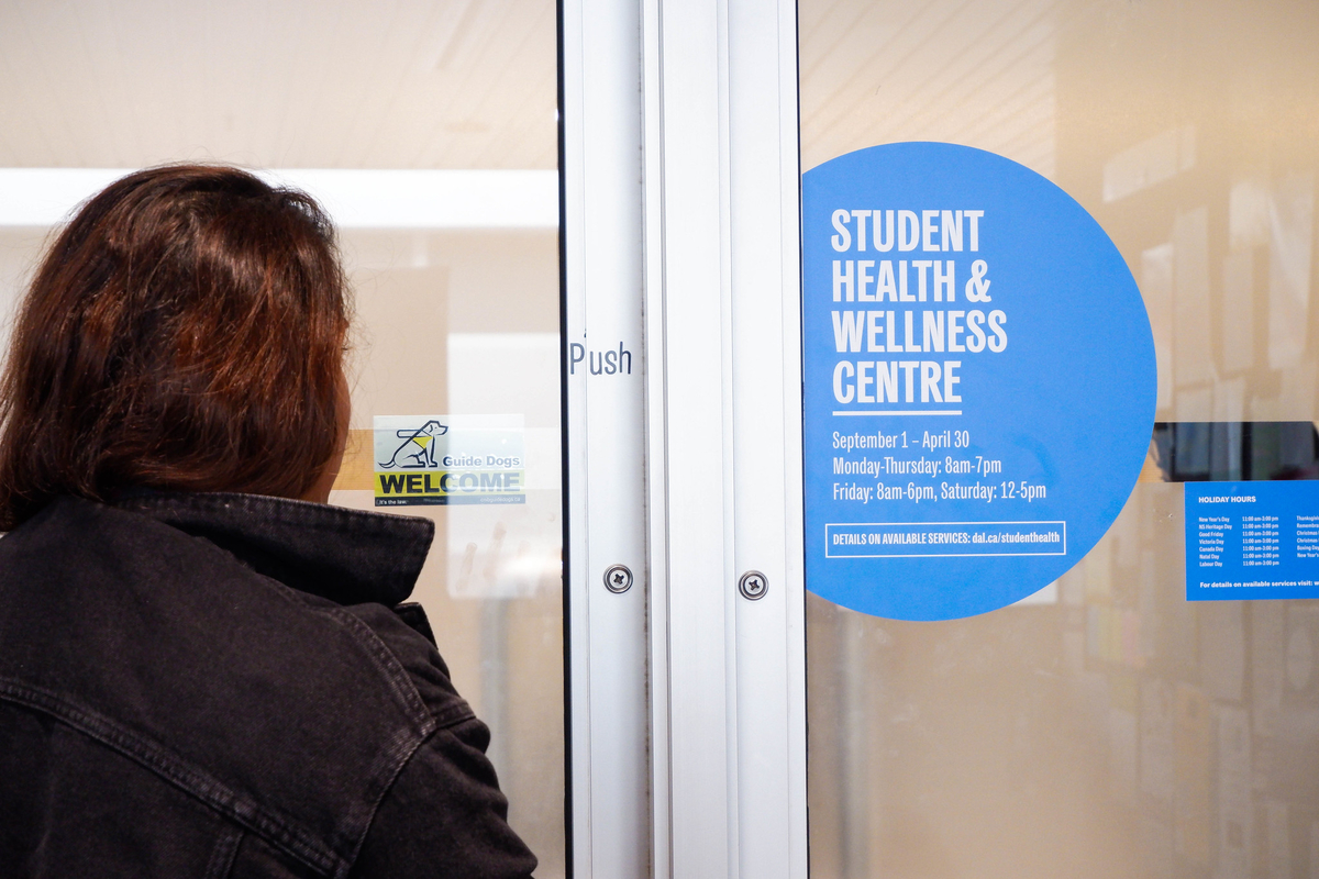 A woman stands outside the doors of the Dalhousie Student Health & Wellness Centre