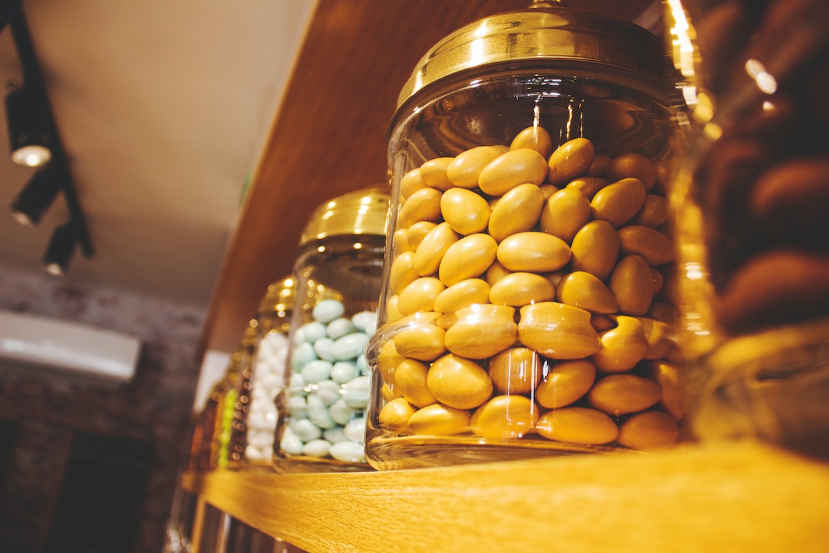 Glass jars of beans on a wooden shelf