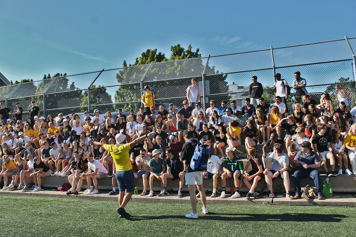 Dalhousie students sitting in the stands of Wickwire field cheering at a soccer game