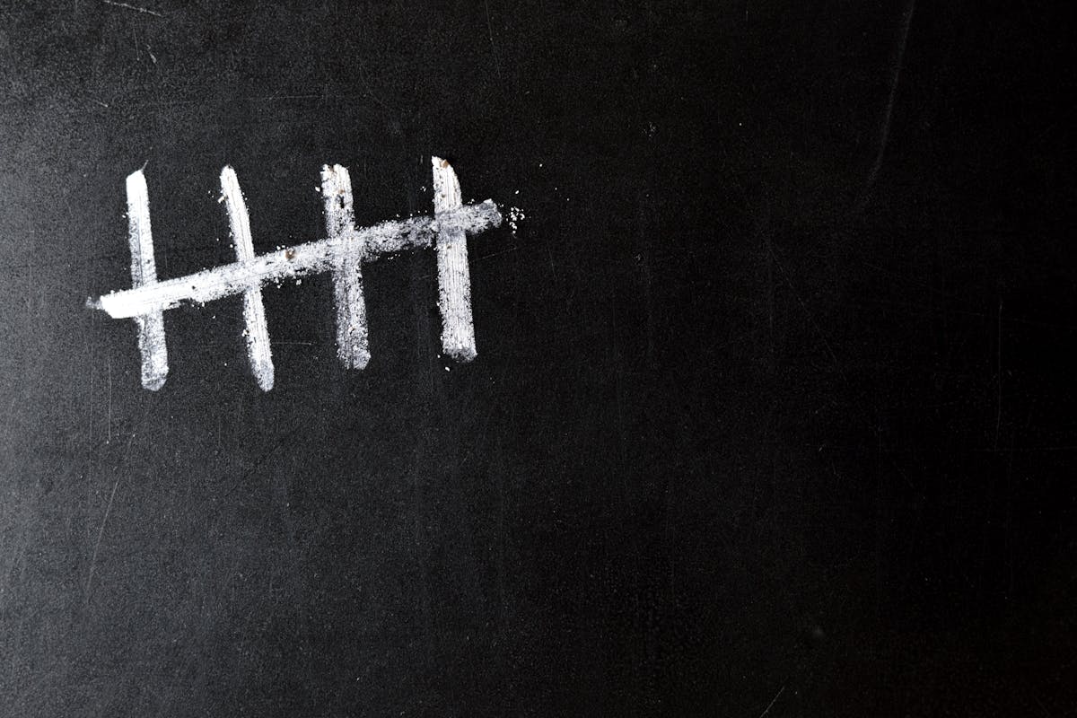 Five chalk lines on a blackboard