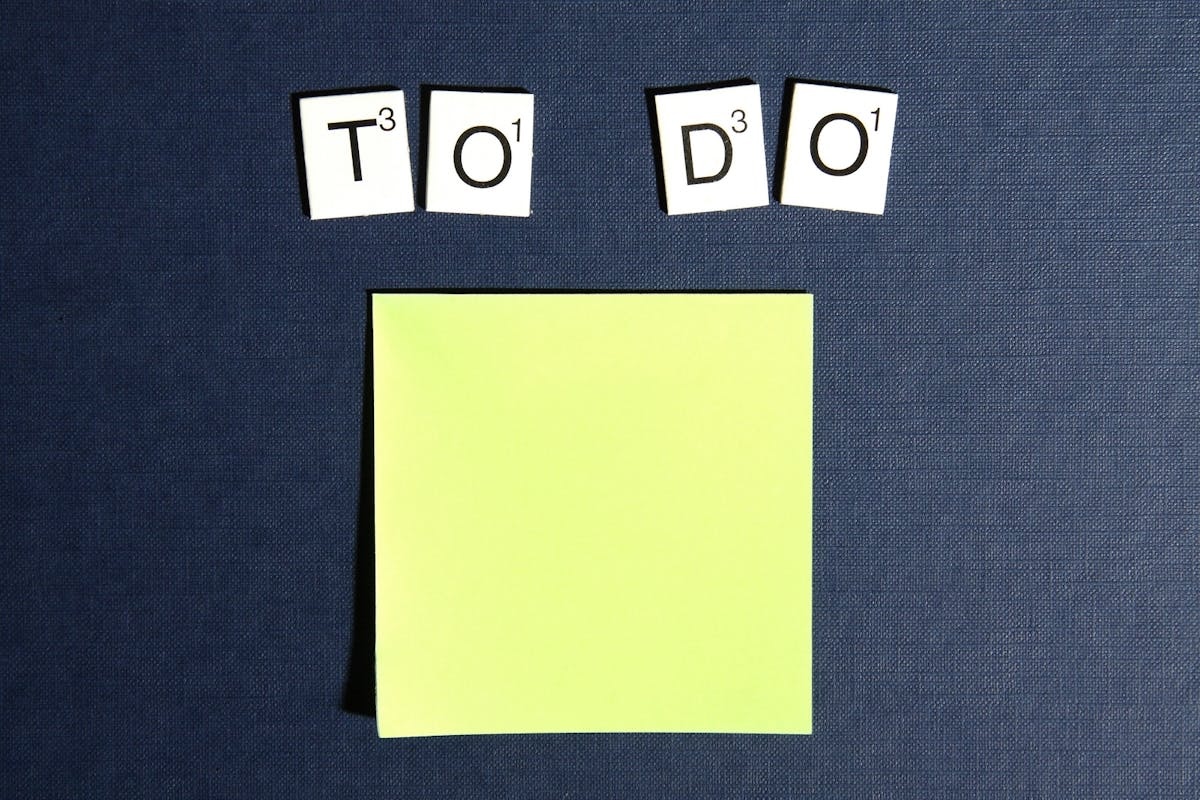 Scrabble tiles spelling To Do above a blank yellow Post-It Note